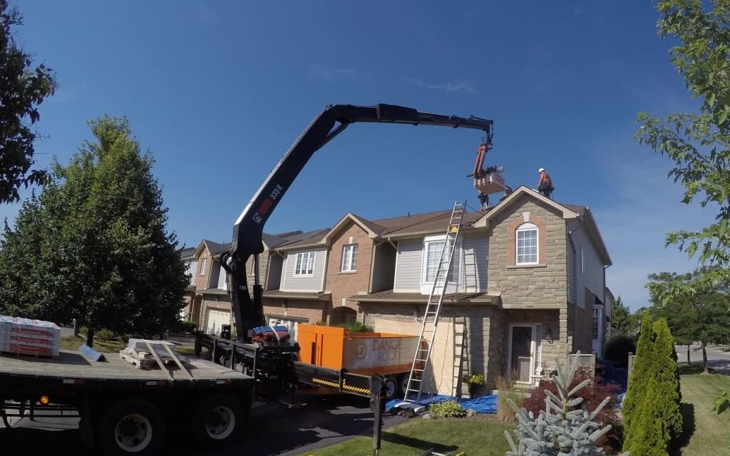 Vaughan roofing repair company fixing damaged shingles on a residential roof with safety equipment.